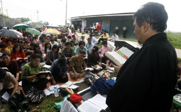 Members of a church congregation attend Sunday service on a road in Tambun, Bekasi regency
